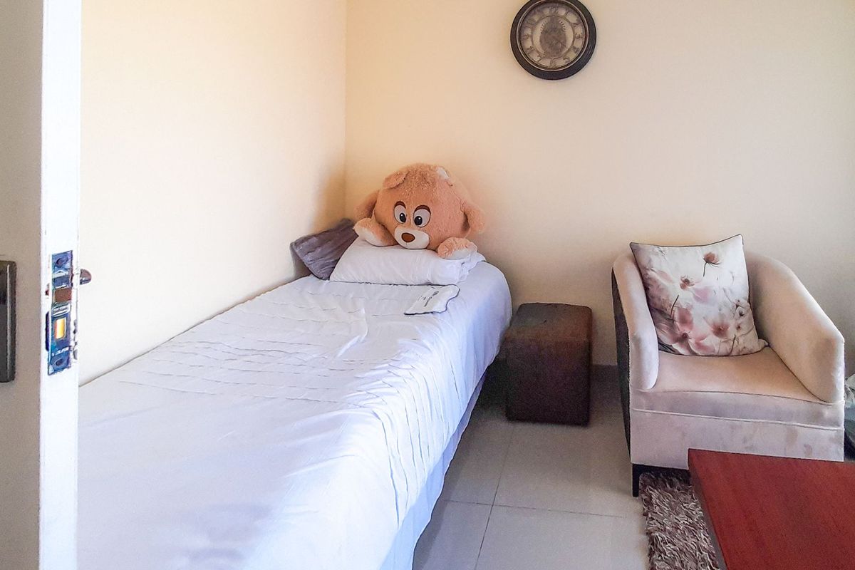 A compact bedroom featuring tiled flooring and neutral wall finishes, suitable for a single bed setup.