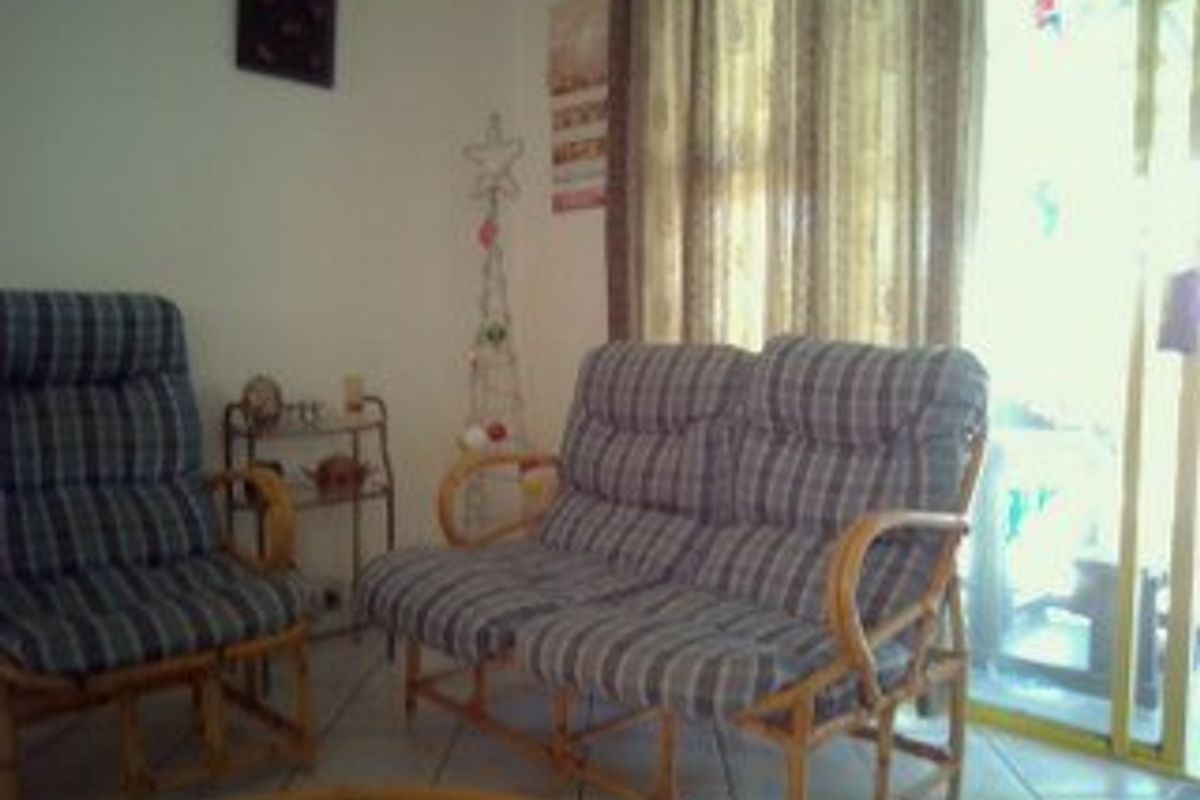 A living room area featuring tiled flooring and a sliding glass door providing access to the exterior.