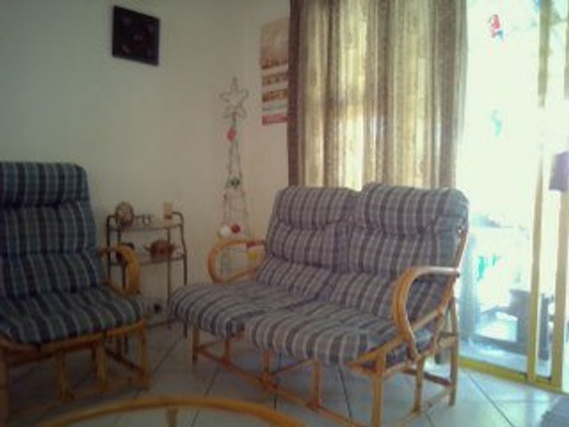 A living room area featuring tiled flooring and a sliding glass door providing access to the exterior.