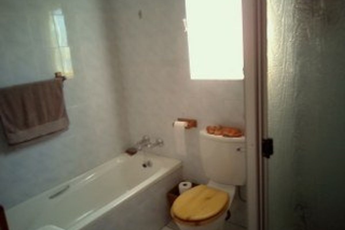 A functional bathroom featuring a bathtub, a separate shower enclosure, and tiled finishes throughout.