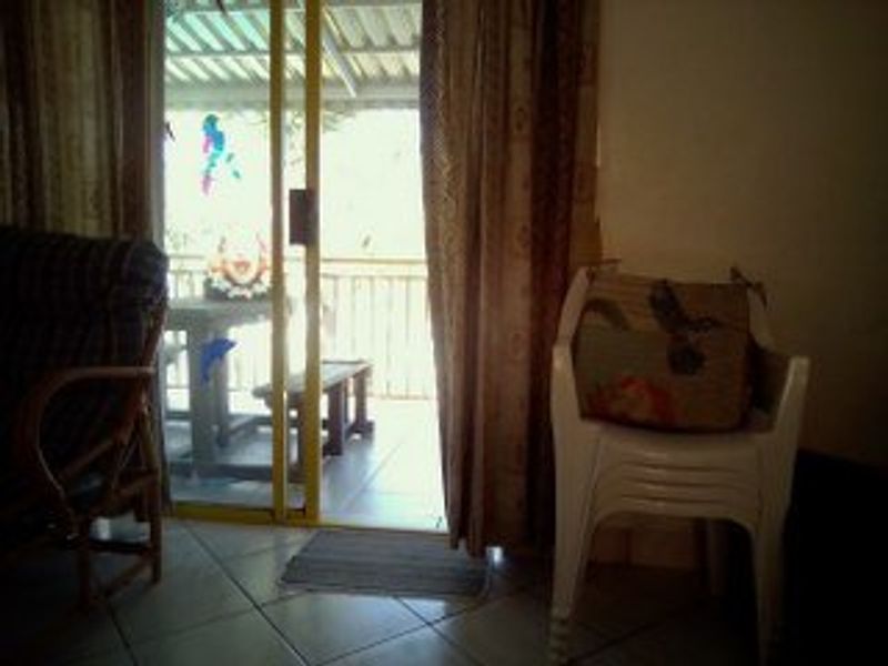 A view from a living area looking out through a sliding glass door onto a covered patio space.