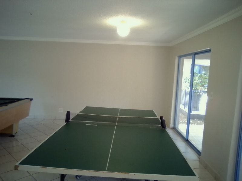 Spacious living area featuring tiled flooring and a sliding glass door providing access to an outdoor balcony.