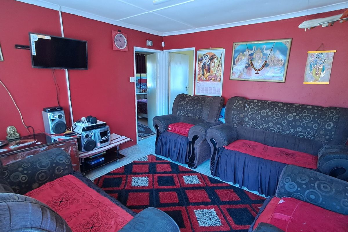 A living room featuring tiled flooring and coved ceilings, currently finished with bold red wall paint.
