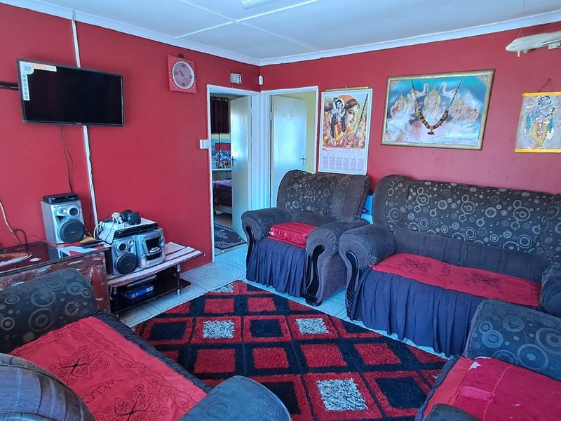 A living room featuring tiled flooring and coved ceilings, currently finished with bold red wall paint.