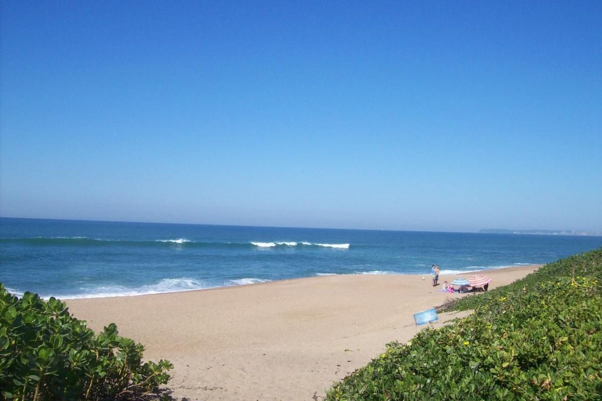 A scenic view of the ocean and sandy beach, showcasing the natural coastal landscape surrounding the property.