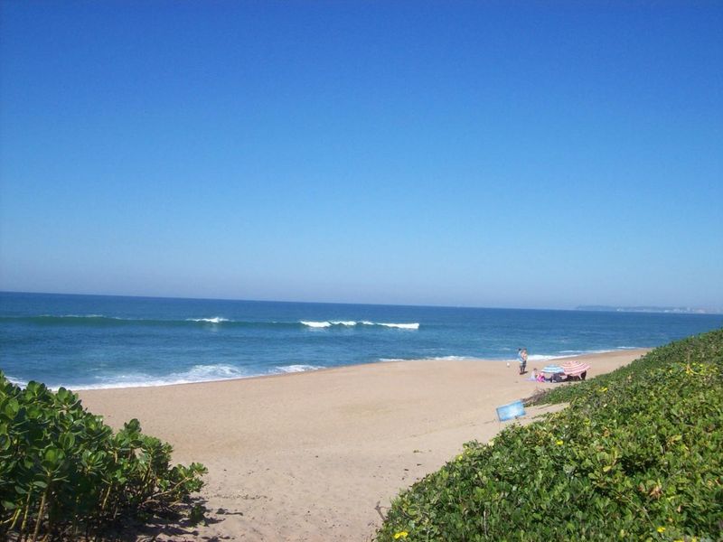 A scenic view of the ocean and sandy beach, showcasing the natural coastal landscape surrounding the property.