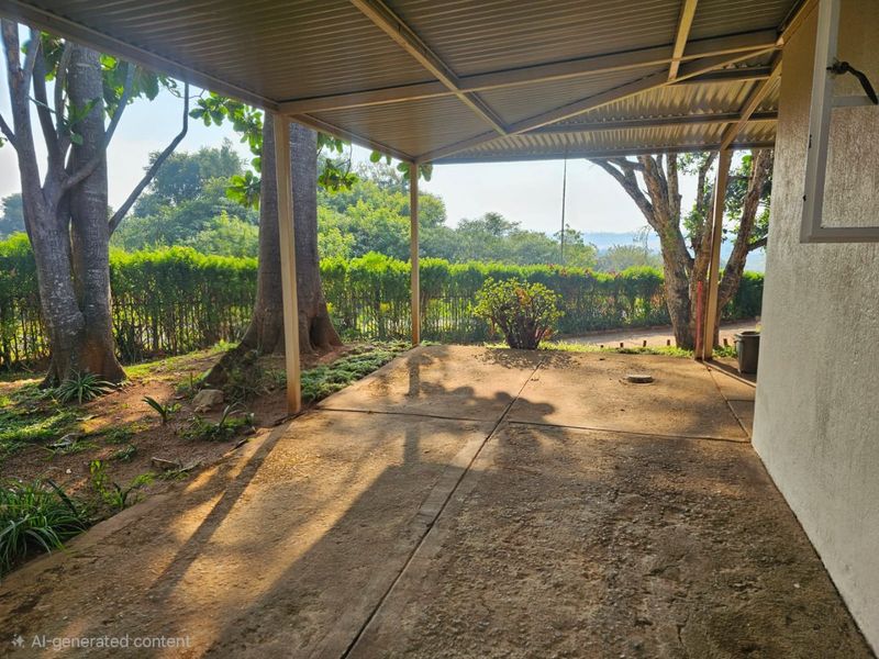 A covered outdoor patio area featuring a concrete slab floor and metal roofing, overlooking a landscaped garden and mature trees.