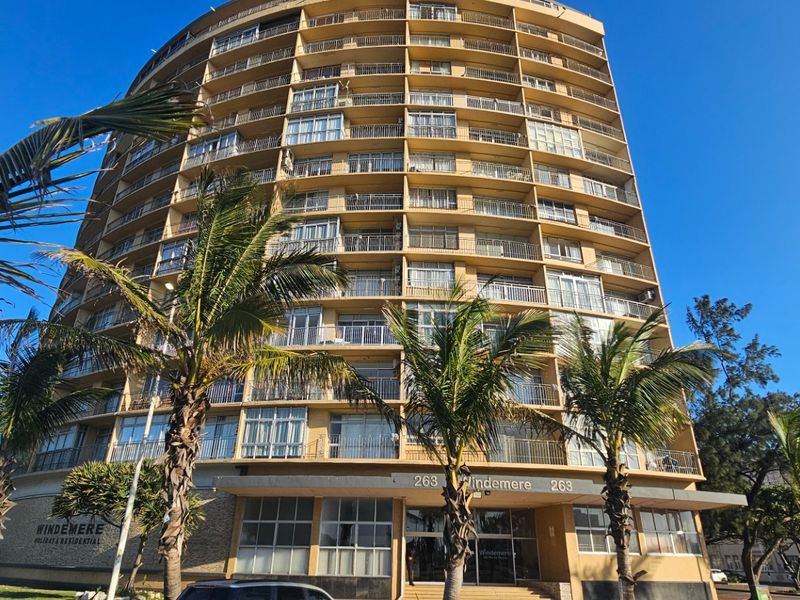 A low-angle view of the Windemere residential building facade, featuring multiple levels of balconies and a ground-level entrance.