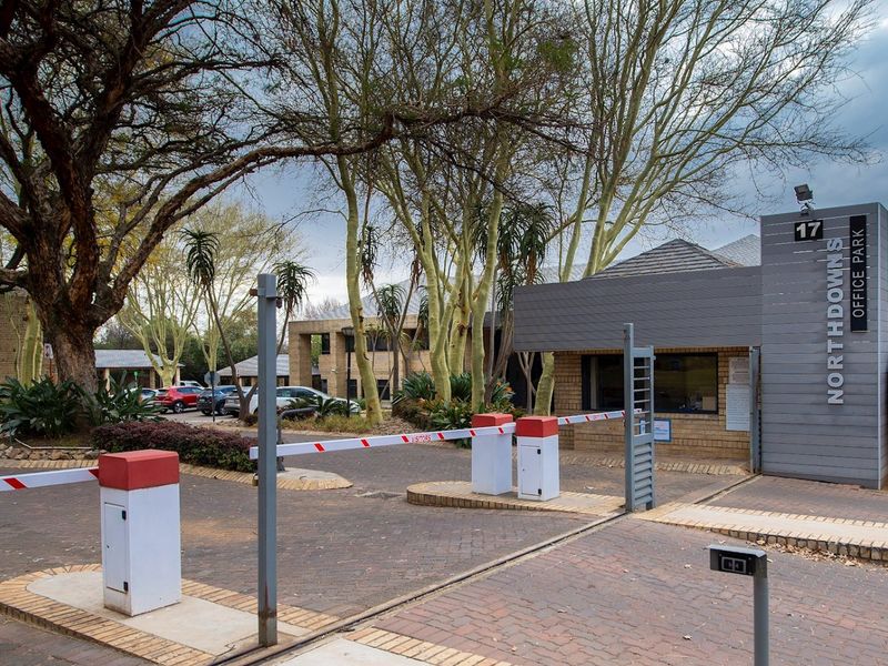 The entrance to Northdowns Office Park featuring a secure boom gate, guard house, and paved driveway access.