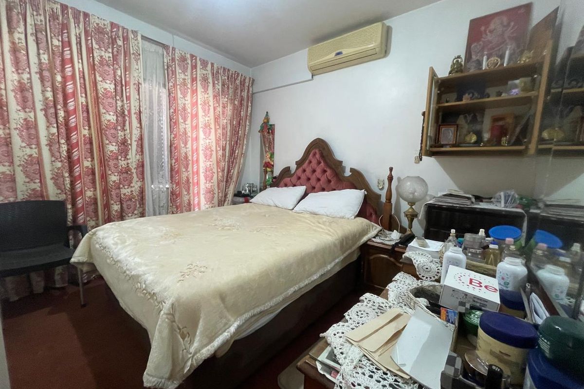A bedroom featuring a wall-mounted air conditioning unit and floor-to-ceiling curtains.
