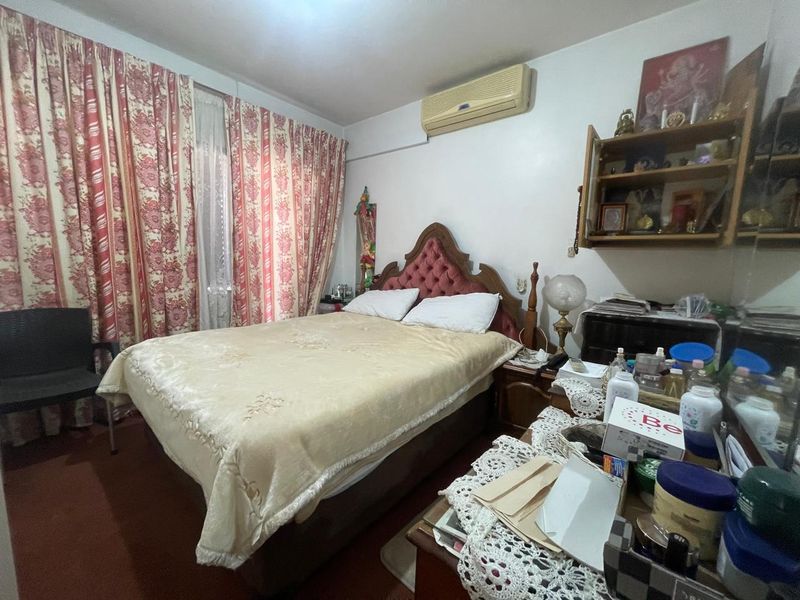 A bedroom featuring a wall-mounted air conditioning unit and floor-to-ceiling curtains.