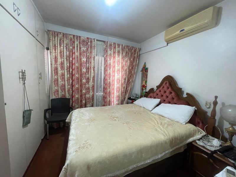 A bedroom featuring built-in wardrobe storage and a wall-mounted split-system air conditioning unit.