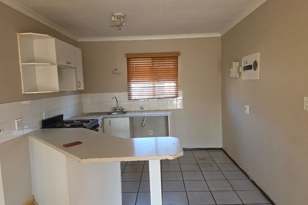 A functional kitchen featuring built-in cabinetry, a breakfast nook, tiled splashbacks, and a built-in stove, offering a blank canvas for renovation.