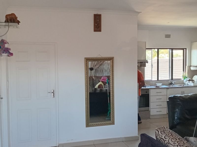 Open-plan living area featuring a functional kitchen with built-in cabinetry, oven, and extractor fan, seamlessly connected to the main living space.
