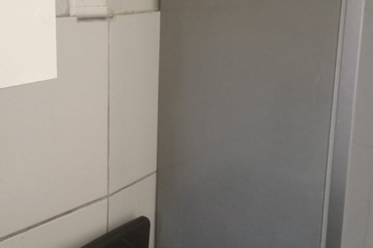 A compact kitchen area featuring a freestanding electric stove and tiled splashback wall finishes.