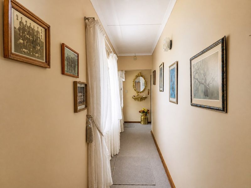A well-maintained interior hallway featuring neutral wall tones, carpeted flooring, and decorative coving, providing a clean and functional transition space within the home.