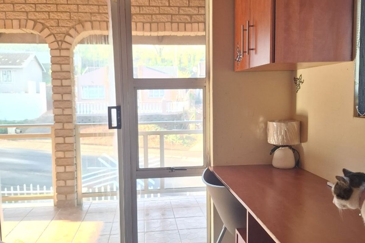 Bedroom featuring a built-in desk and cabinetry, tiled flooring, and a sliding glass door providing access to a covered patio area.