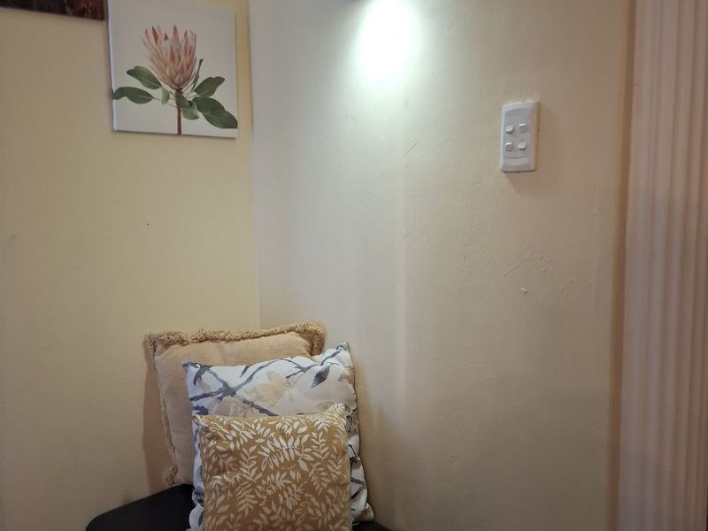 A small corner area featuring a wall-mounted light fixture and light switch, finished with neutral wall paint.