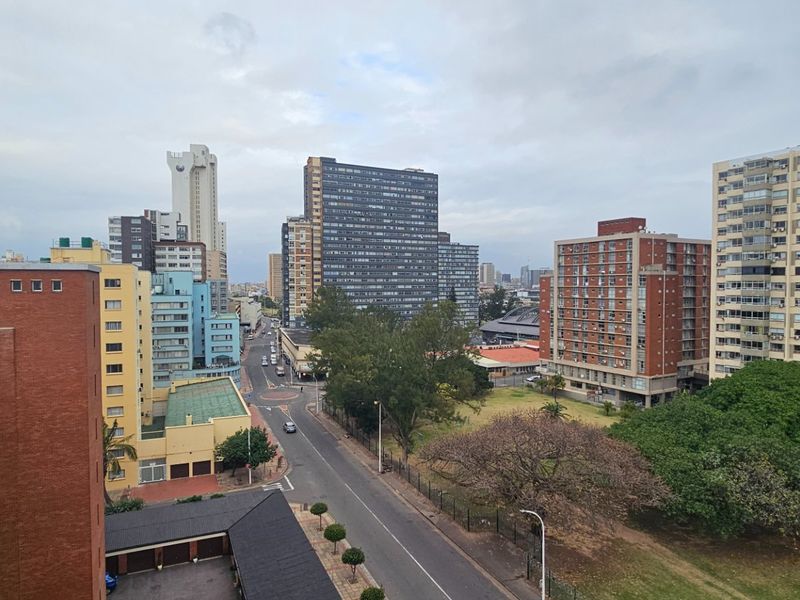 An elevated urban view overlooking surrounding apartment buildings, streets, and green spaces in a high-density residential area.