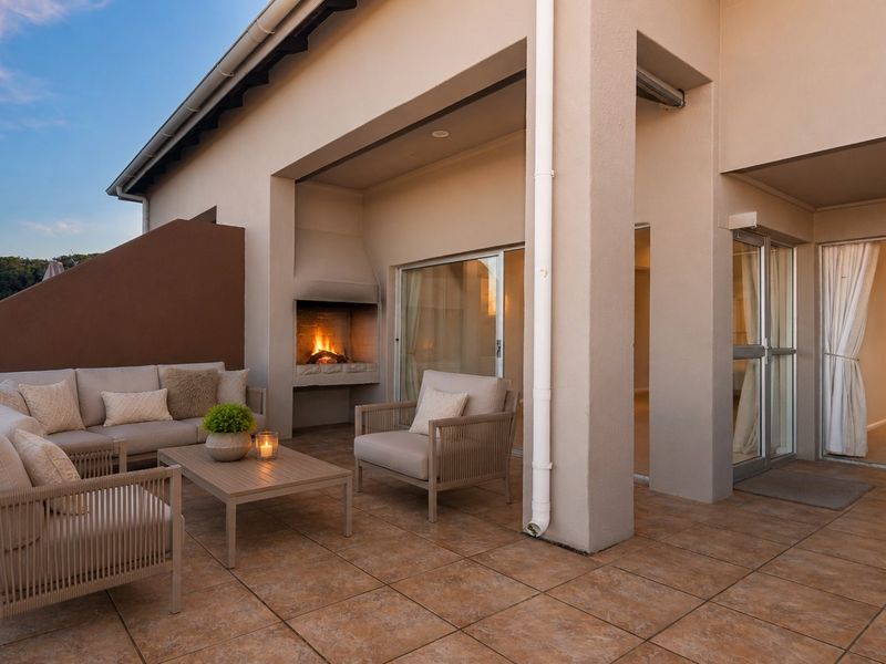 Spacious covered patio featuring a built-in fireplace, tiled flooring, and seamless access to the interior living areas through sliding glass doors.