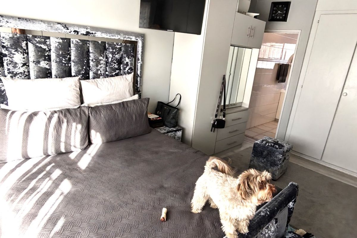 A bedroom featuring built-in cupboards and direct access to an en-suite bathroom.