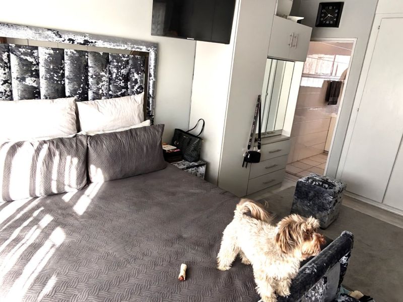 A bedroom featuring built-in cupboards and direct access to an en-suite bathroom.