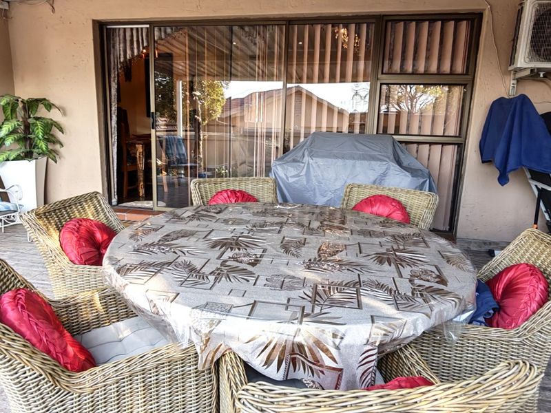 Covered patio area featuring tiled flooring and sliding glass door access to the interior, equipped with an external air conditioning unit.