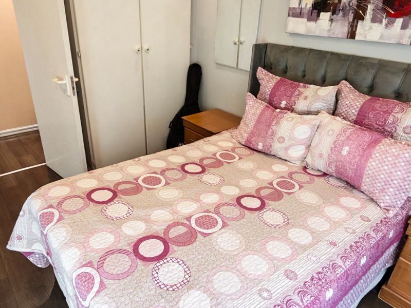 A bedroom featuring laminate flooring and a built-in wardrobe, providing functional storage space within the townhouse.