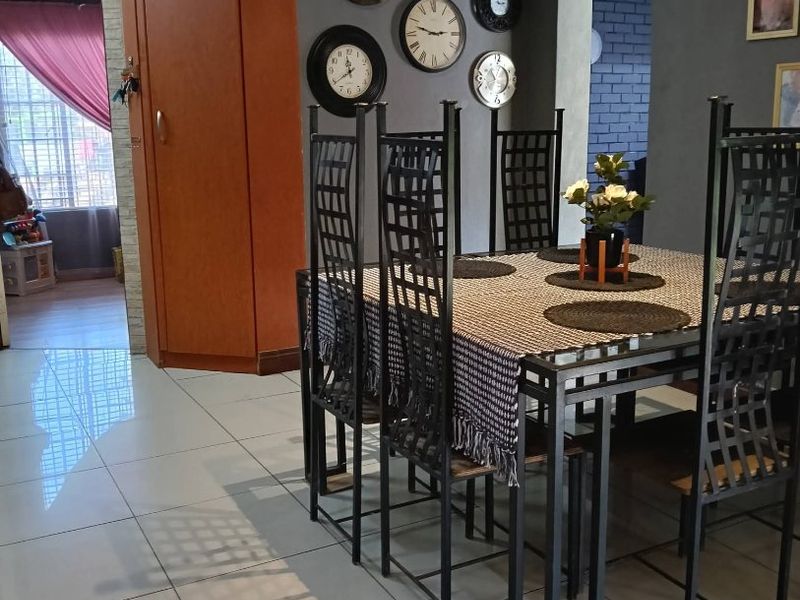 A dining area featuring light-colored floor tiles, a coved ceiling, and built-in corner cabinetry, providing a functional space for meals.