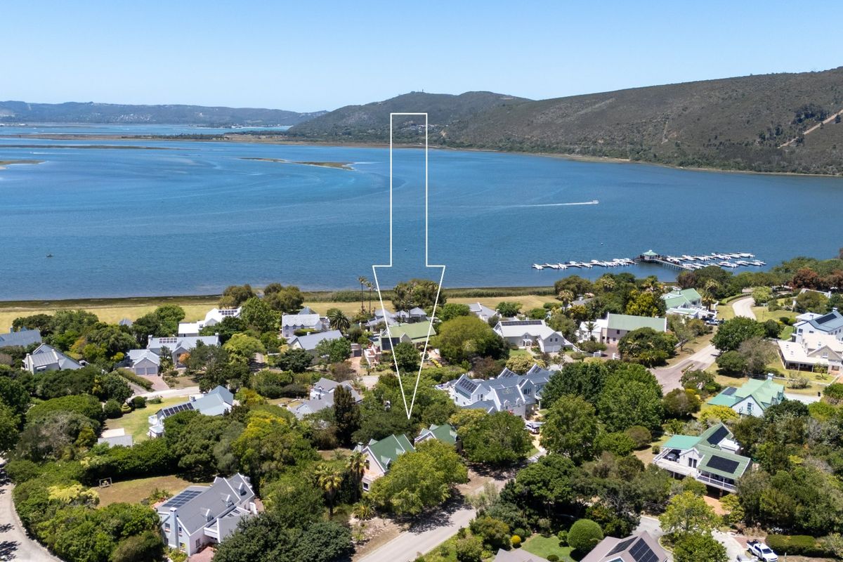 Aerial view of a residential estate situated along a scenic lagoon, showcasing the property location and surrounding landscape.
