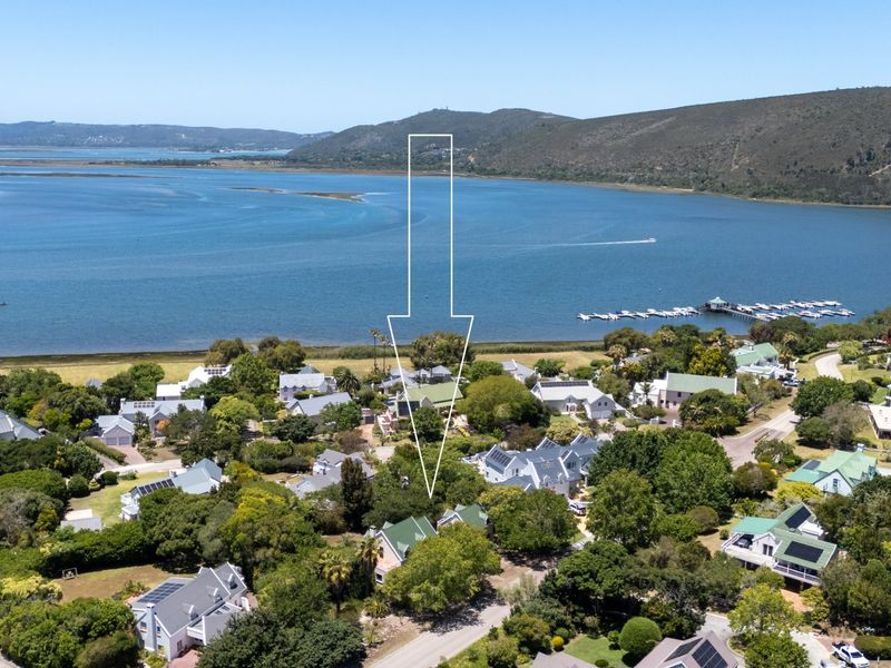 Aerial view of a residential estate situated along a scenic lagoon, showcasing the property location and surrounding landscape.