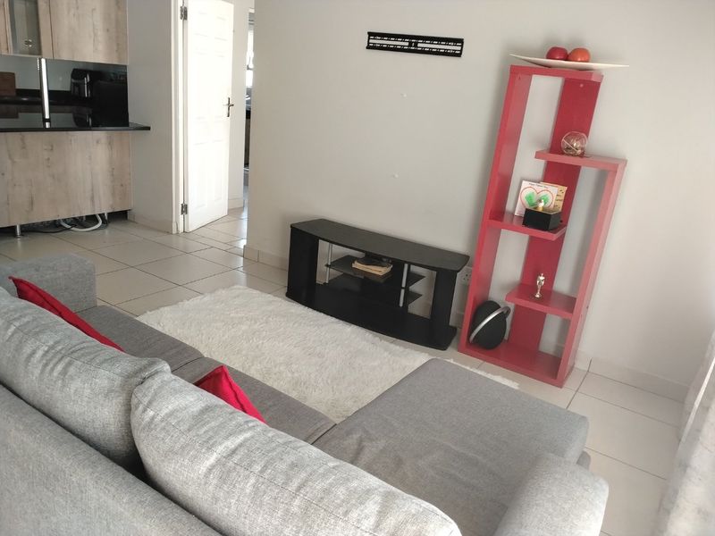 Open plan living area featuring tiled flooring and a compact kitchen with granite countertops, providing a functional and connected living space.