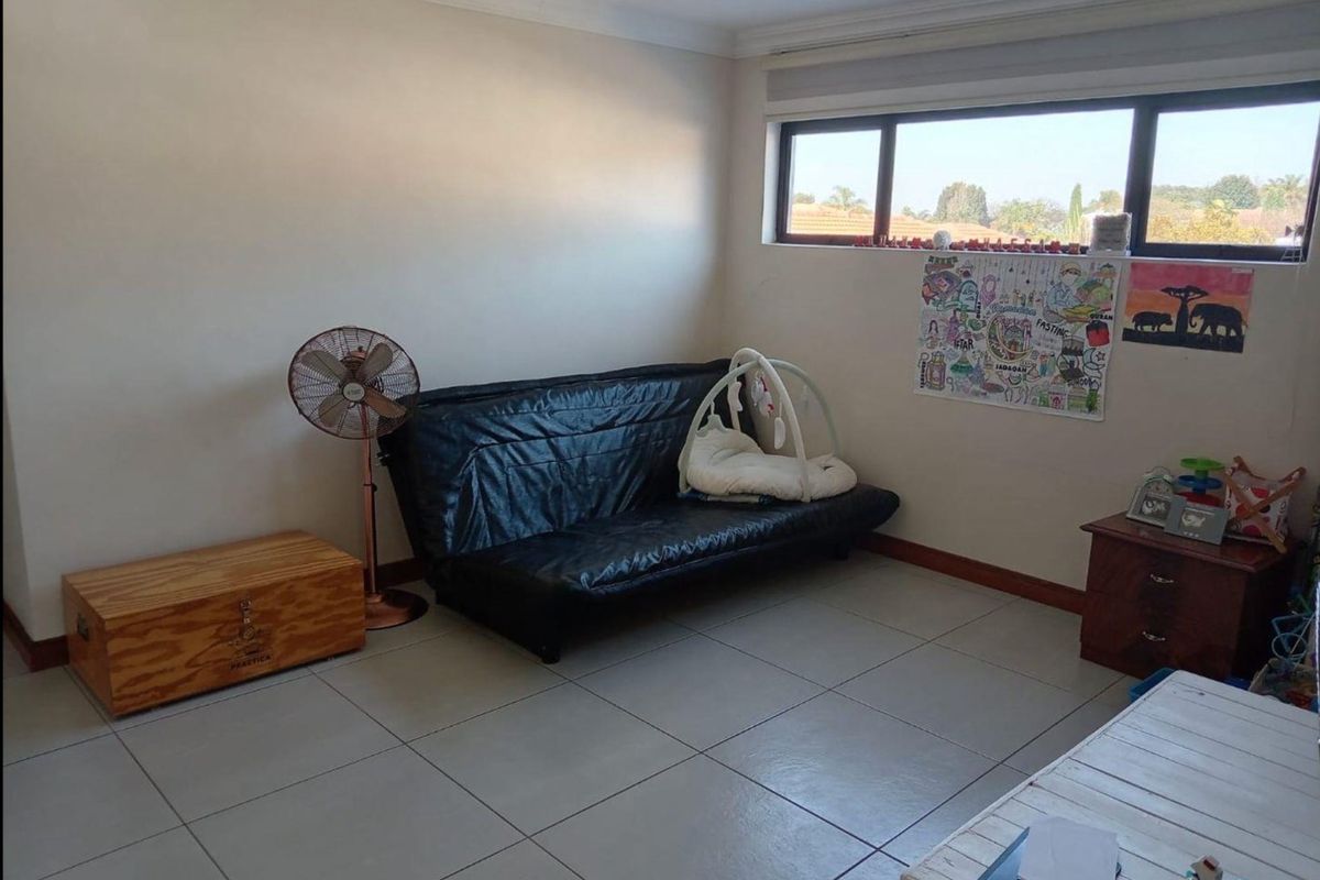 A bedroom featuring neutral tiled flooring, recessed downlighting, and a large window providing natural light.