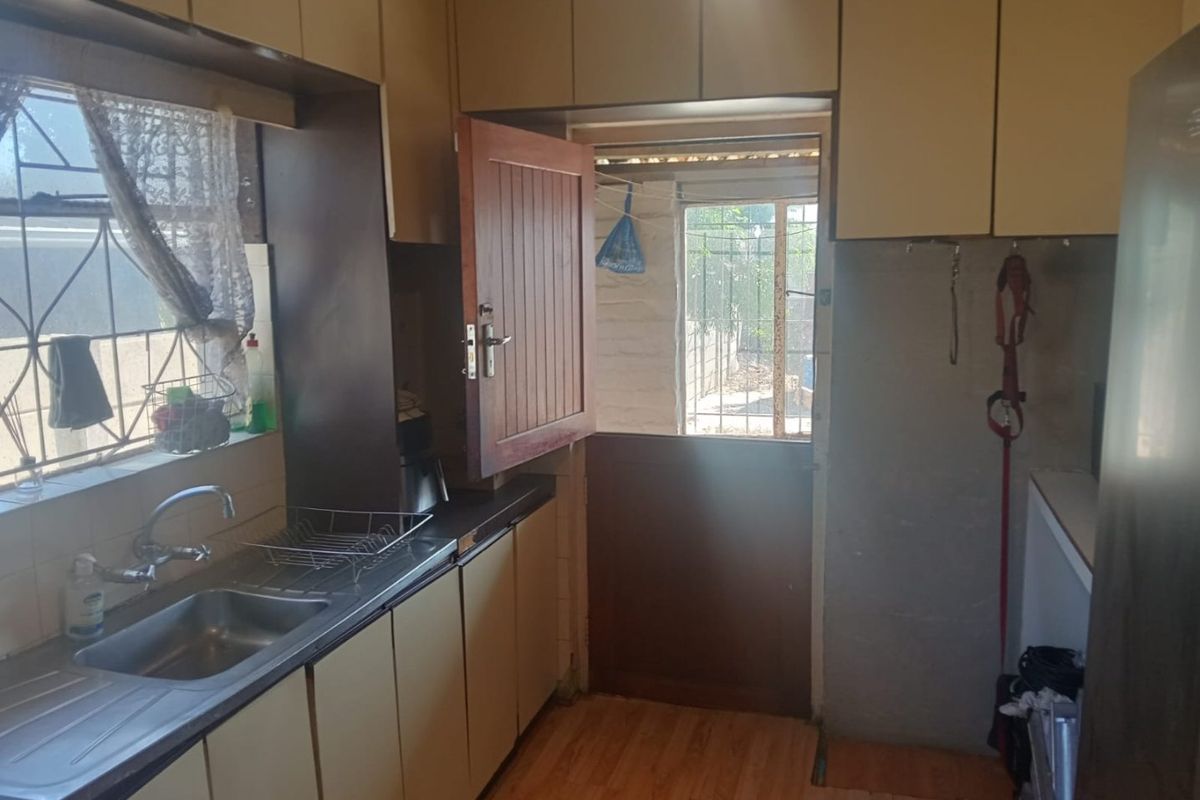 A functional kitchen featuring laminate cabinetry, a stainless steel sink, and a stable door providing direct access to the exterior.