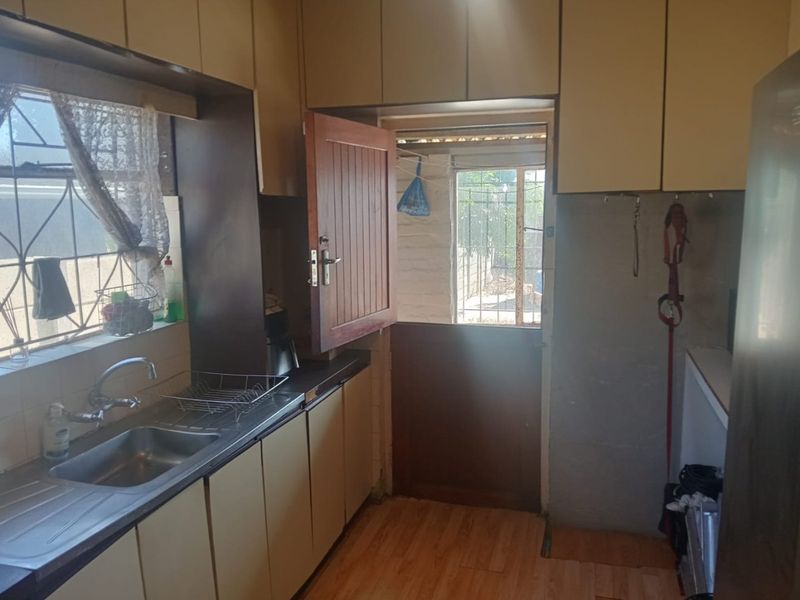 A functional kitchen featuring laminate cabinetry, a stainless steel sink, and a stable door providing direct access to the exterior.