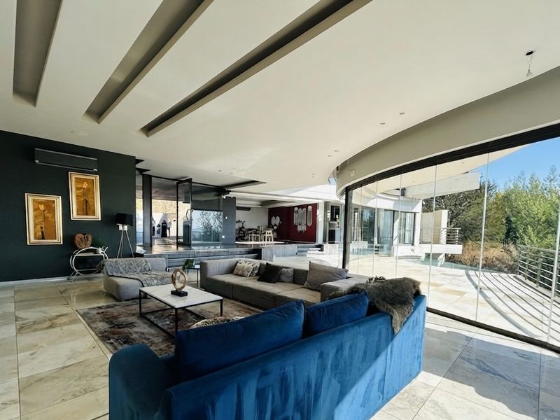 Spacious open-plan living area featuring high-end marble flooring, a dramatic recessed ceiling, and expansive floor-to-ceiling glass walls overlooking the outdoor terrace.