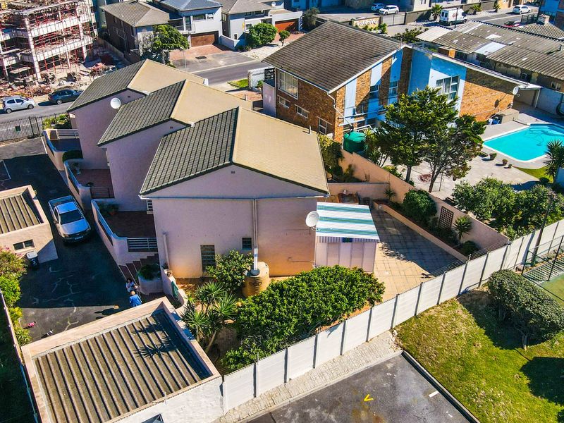 Aerial view of the townhouse property showing the roof structure, paved driveway, private patio area, and surrounding boundary walls.