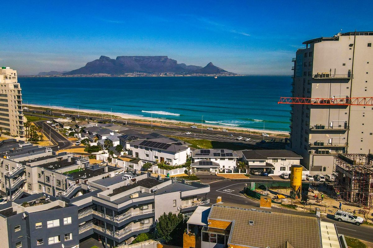 Aerial view of the coastal neighbourhood featuring Table Mountain in the background and proximity to the beach.