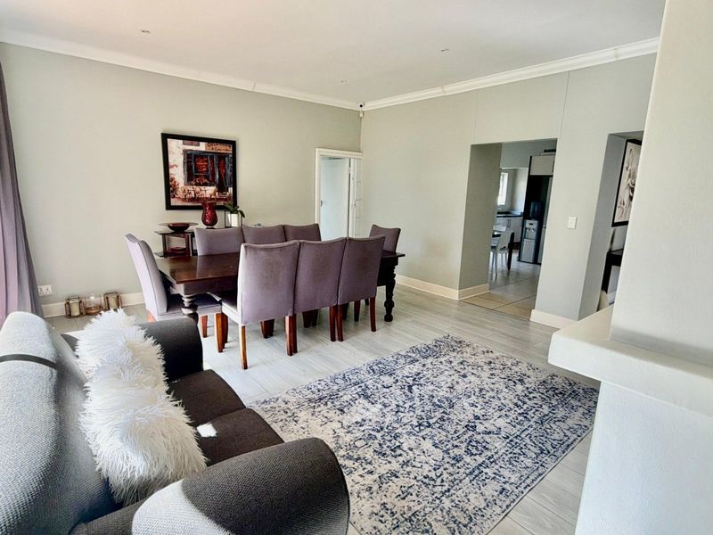 Spacious open-plan living and dining area featuring neutral tones, tiled flooring, and direct access to an outdoor patio through sliding glass doors.