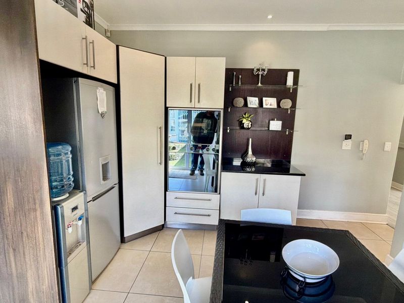 A functional kitchen featuring built-in cabinetry, granite countertops, and a built-in oven, complemented by neutral tiled flooring.