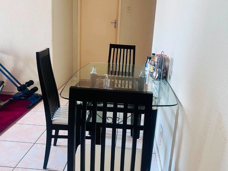 A dining area featuring tiled flooring and a neutral interior, providing a functional space for meals within the townhouse.