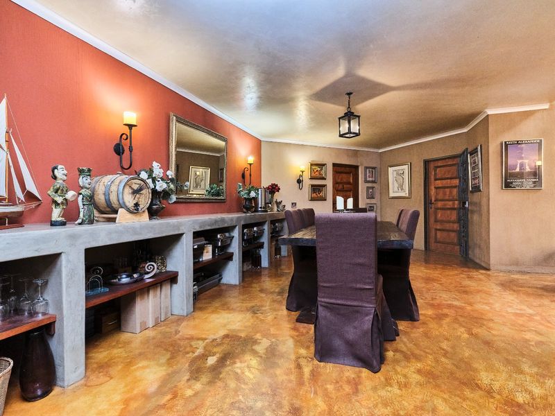 Spacious dining room featuring a unique built-in concrete sideboard, warm-toned walls, and polished stained concrete flooring with traditional timber door accents.