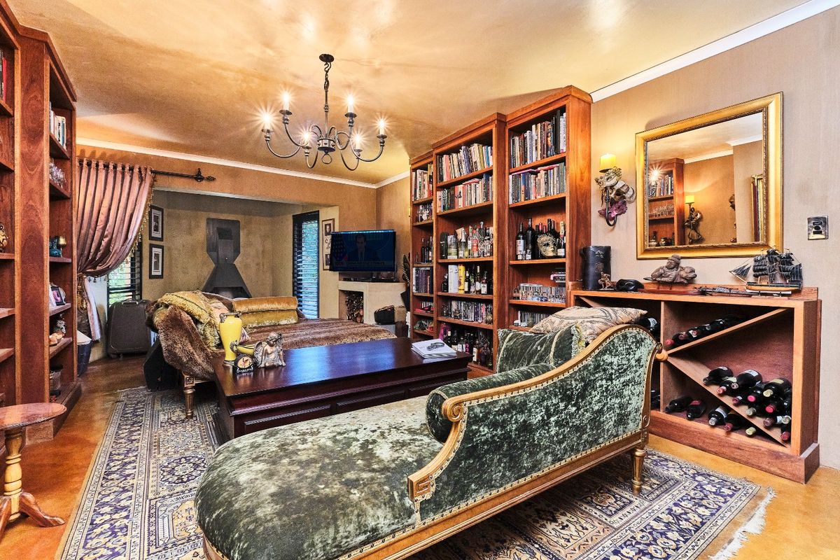 A cozy living room featuring extensive built-in wooden shelving, a dedicated wine storage unit, and a fireplace, creating a warm and inviting atmosphere.