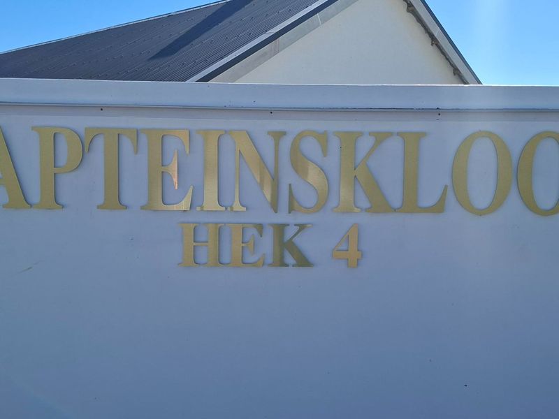 A clear view of the property boundary wall featuring metal signage for Kapteinskloof Hek 4.