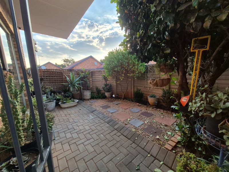 A private paved patio area featuring a gravel garden bed with stepping stones and timber boundary fencing.