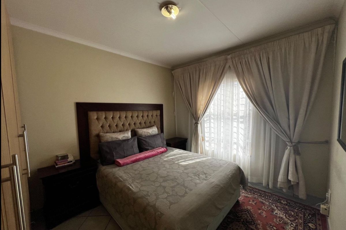 A well-lit bedroom featuring a built-in cupboard and neutral wall finishes, offering a comfortable and functional living space.