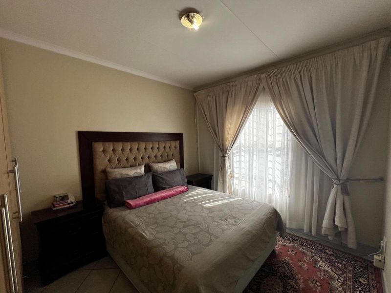 A well-lit bedroom featuring a built-in cupboard and neutral wall finishes, offering a comfortable and functional living space.