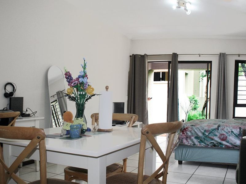 Open-plan living and sleeping area featuring tiled flooring and a sliding glass door providing access to the exterior.