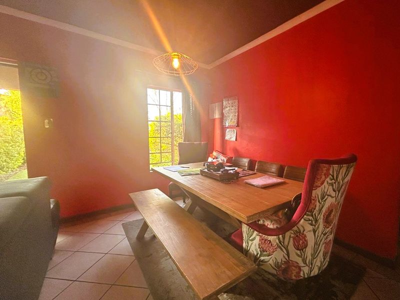 A dining room featuring tiled flooring and natural light from a window, providing a functional space for meals.