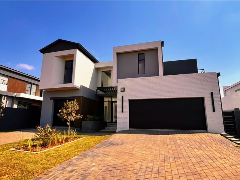 Modern double-story residential property featuring a contemporary facade, paved driveway, and integrated double garage in a well-maintained estate setting.